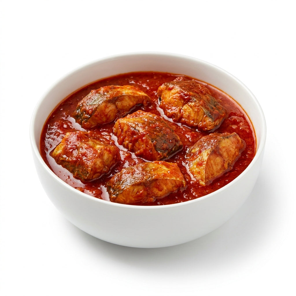 A white ceramic bowl filled with cooked fish pieces in a rich red tomato sauce, presented on a clean white background.