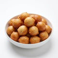 Golden-brown fried dough balls, commonly known as mochi or fried fritters, piled in a white ceramic bowl on a clean white background.