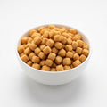 A white ceramic bowl filled with small golden-brown cube-shaped snack pieces, photographed on a clean white background.
